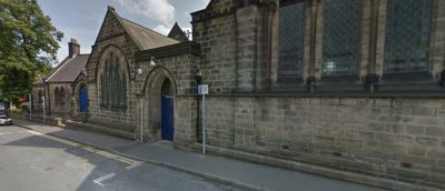 Stone building with arched windows and blue doors.