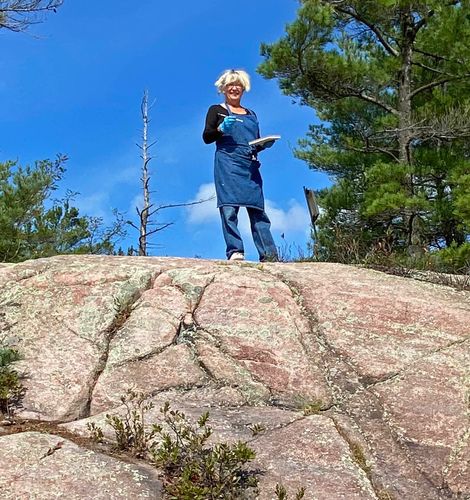 Laurie De Camillis standing on the top of a Precambrian rock ready to paint.