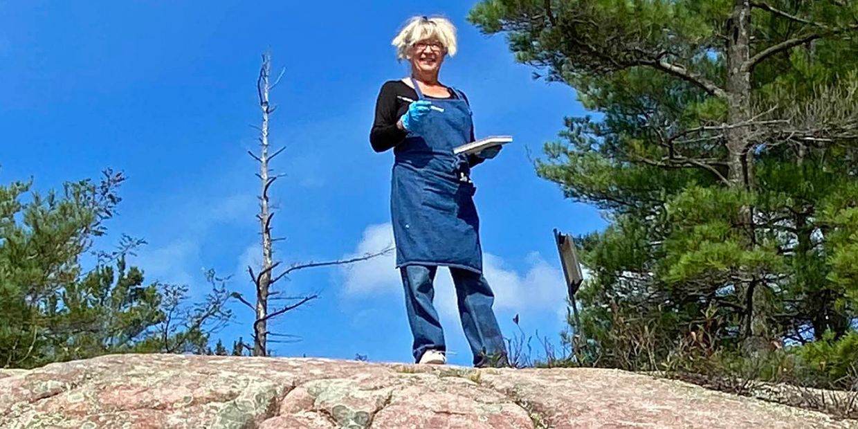 plein air painter standing on the top of a Georgian Bay Rock