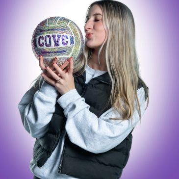 Woman holding and kissing a sparkling volleyball.