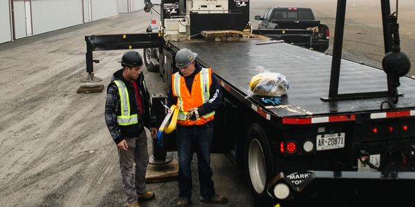boom truck rental with operator setting up rigging for crane lift