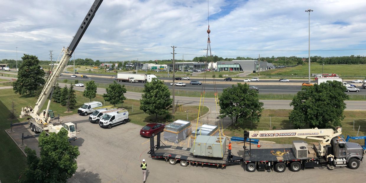 Boom truck and mobile crane rental hoisting HVAC units to roof in Mississauga, Ontario