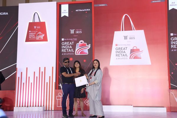 Three people receiving an award at the Great India Retail Awards event.
