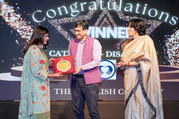 A woman receives an award from a man on stage during a ceremony.