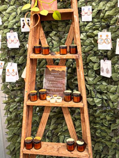 Wooden ladder display with jars and earrings.