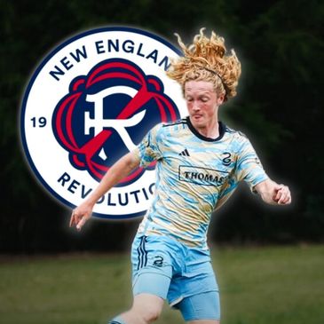 Soccer player in blue kit dribbling ball with New England Revolution logo in background.