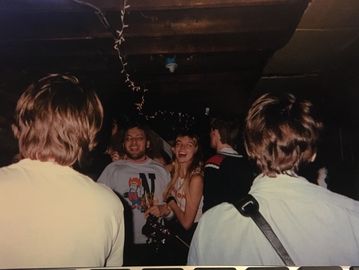 People socializing in a dimly lit room with string lights.