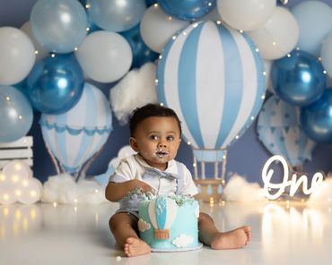 hot air balloon cake smash session of little boy eating cake during his session in chino hills ca.