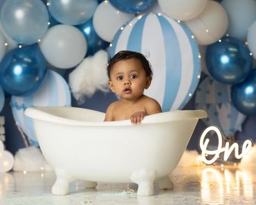 hot air balloon cake smash with little boy in smash bath at his one year photo session in corona.