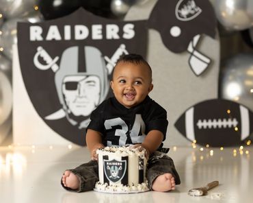 boy smashing cake during his Raider cake smash session in studio in chino hills ca photo studio.