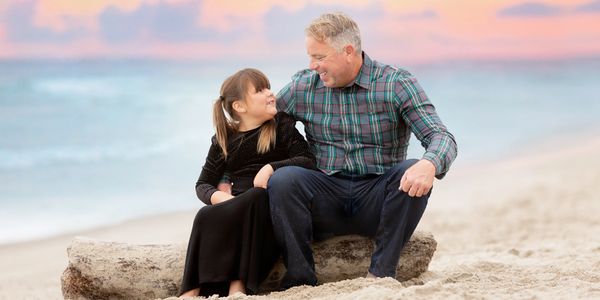 father and daughter at Newport Beach photos session laughing during a family session.