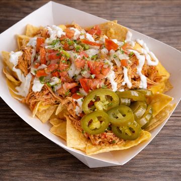 Crispy tortilla chips topped with nacho cheese, sour cream, jalapeños, and your choice of chicken or