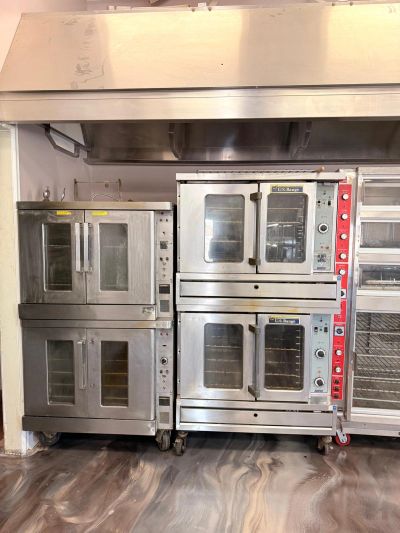 Commercial kitchen ovens and racks in a professional setting.