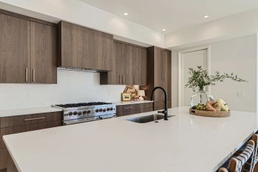 Modern kitchen with wooden cabinets and white countertop island.