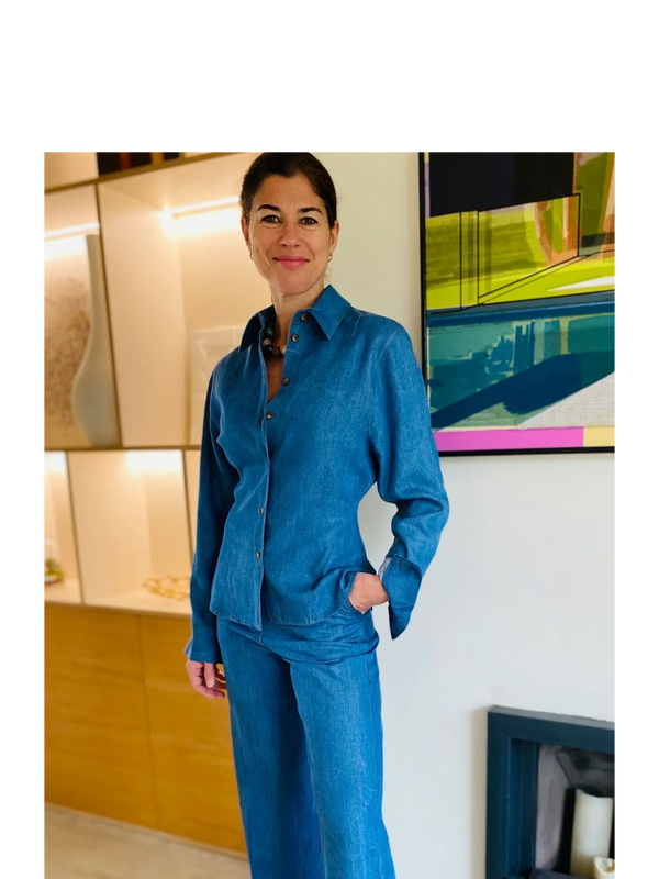 Woman in a blue denim outfit with leopard print shoes, standing indoors.