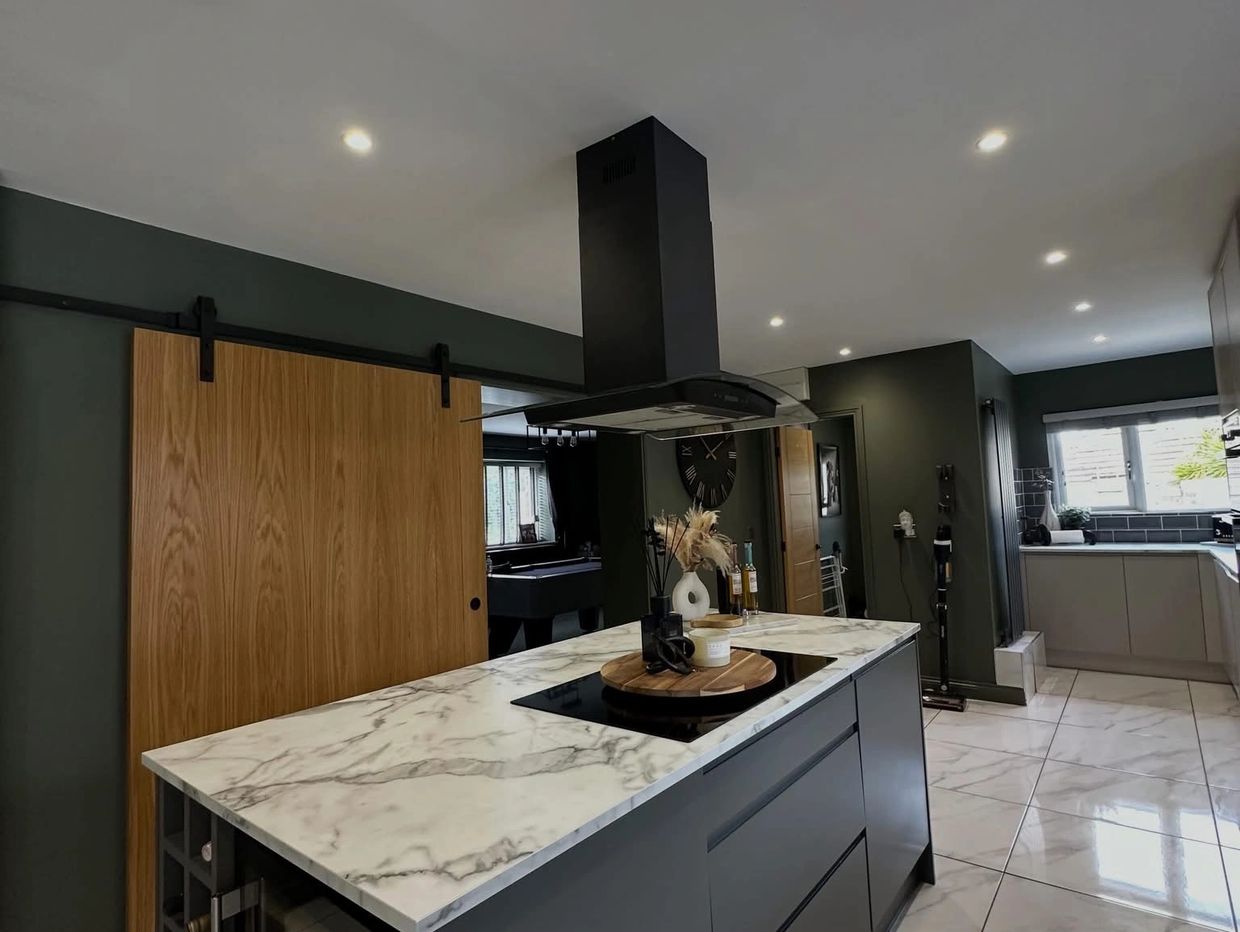Modern kitchen with marble island and wooden sliding door.
