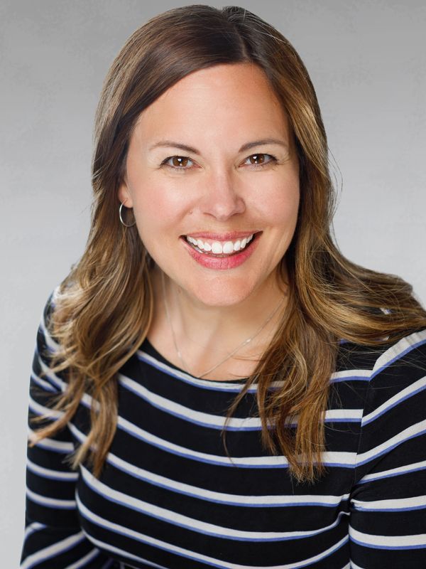 Smiling woman with brown hair in striped shirt