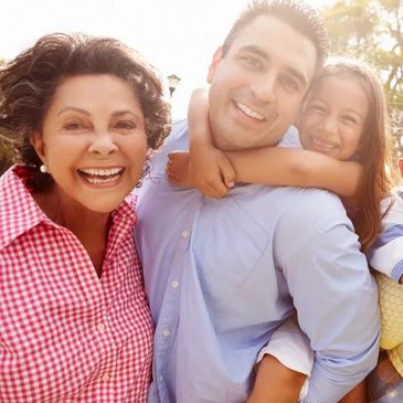 Grandmother, father, and daughter, all smiling