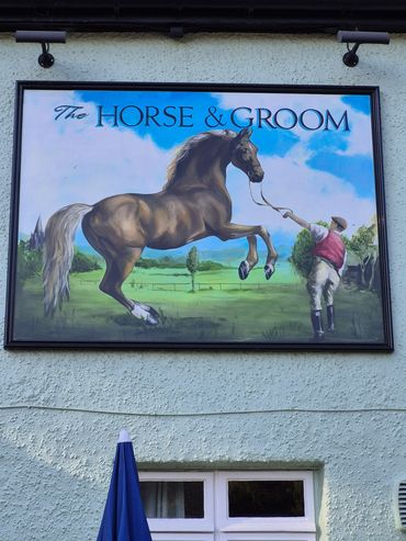 Signboard of 'The Horse &amp; Groom' with a horse and groom illustration.