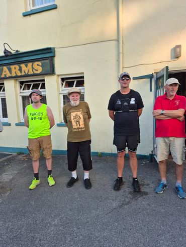 Four men standing outside a pub.