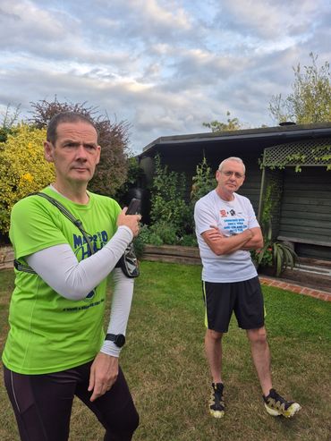 Two men in athletic wear standing in a garden.