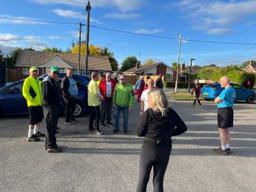 Group of people gathered outdoors on a sunny day in a residential area.