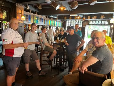 Group of men socializing in a pub with drinks.
