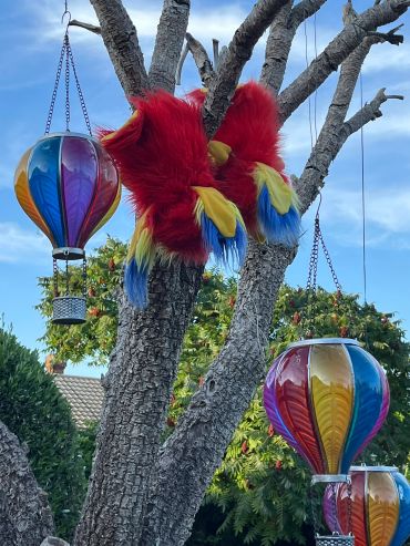 Colorful hot air balloon decorations and red bird figures in a tree.