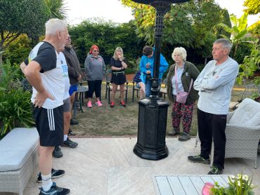 Group of people standing outside in a garden area.