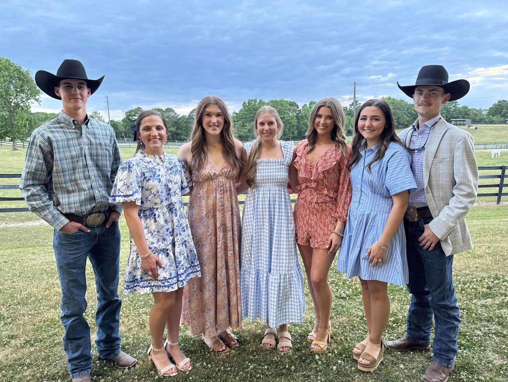 Group of young people dressed in country-style attire outdoors.
