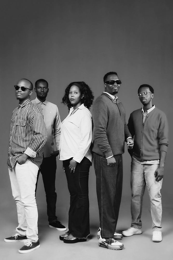 Five stylish individuals posing confidently in a black-and-white studio portrait.