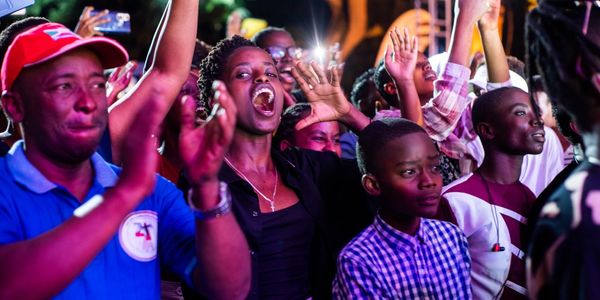A lively crowd cheering and clapping at an event.