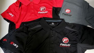Three branded polo shirts in red, gray, and black for Findlay Restoration Inc.