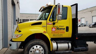 International truck wrapped from red to yellow with logos on door for Home Hardware.