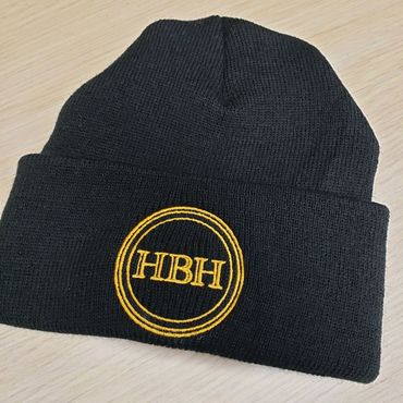 Black knit beanie with yellow embroidered HBH logo.