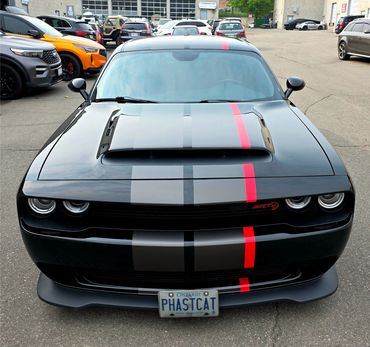 Black Dodge Challenger with racing stripes and custom license plate PHASTCAT.