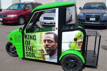 Green vehicle with a portrait and "King of the Soil" text on its side.