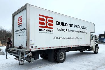 A Buchner Manufacturing delivery truck parked on a snowy lot.