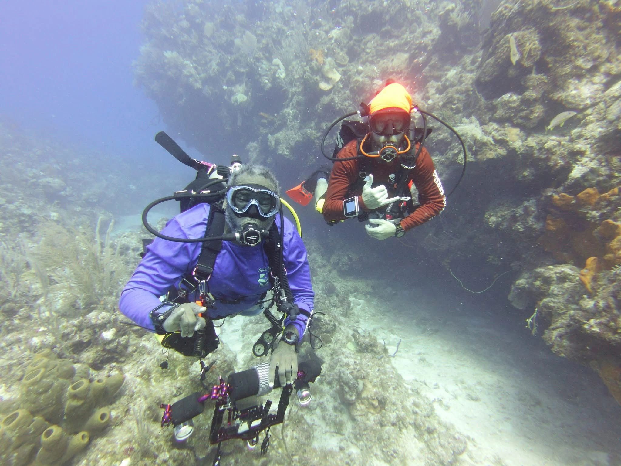 Two scuba divers exploring a coral reef underwater in the Caymans.