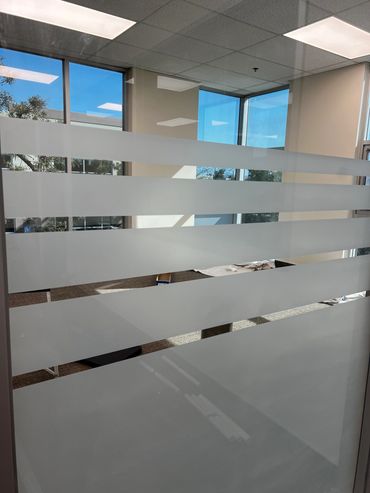 Office window with frosted horizontal stripes.