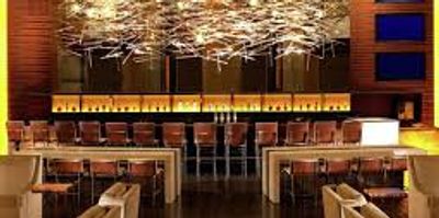 Modern bar with stylish hanging lights and wooden decor.