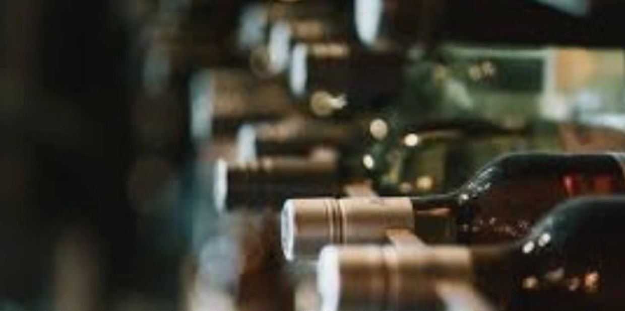 Close-up of wine bottles stored horizontally in a cellar or rack.