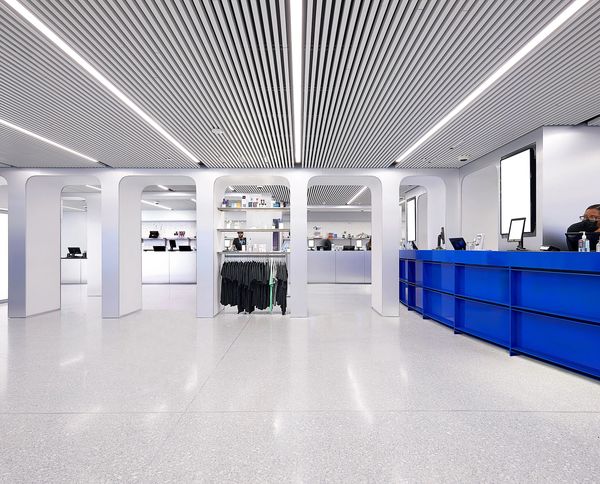 Modern retail store interior with white arches and a blue counter.