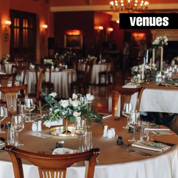 Elegant wedding reception venue with round tables and floral centerpieces.