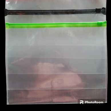 Two transparent plastic zipper bags, one with a black zipper and one with a green zipper.