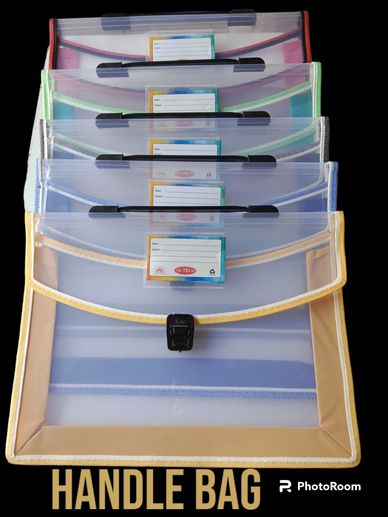 Stack of colorful transparent handle bags with labels and clasps.