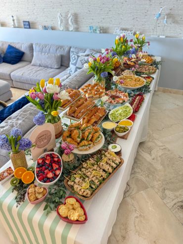 Elegant table with assorted appetizers and floral arrangements.