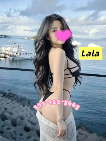 Woman posing on waterfront in black bikini.