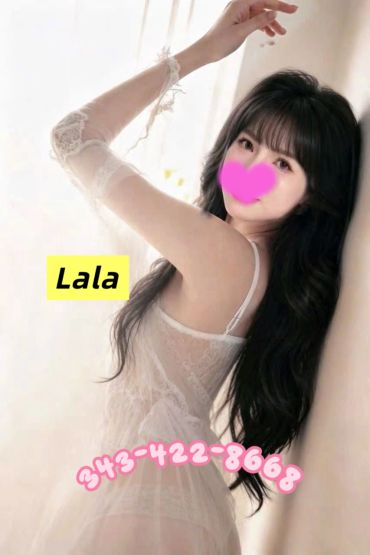 Woman in sheer white dress with long dark hair posing.