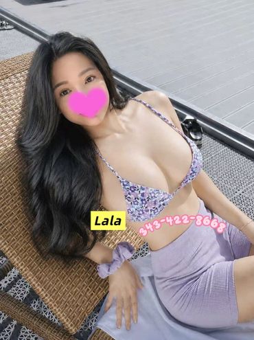 Woman relaxing outdoors in a floral bikini top and purple skirt.